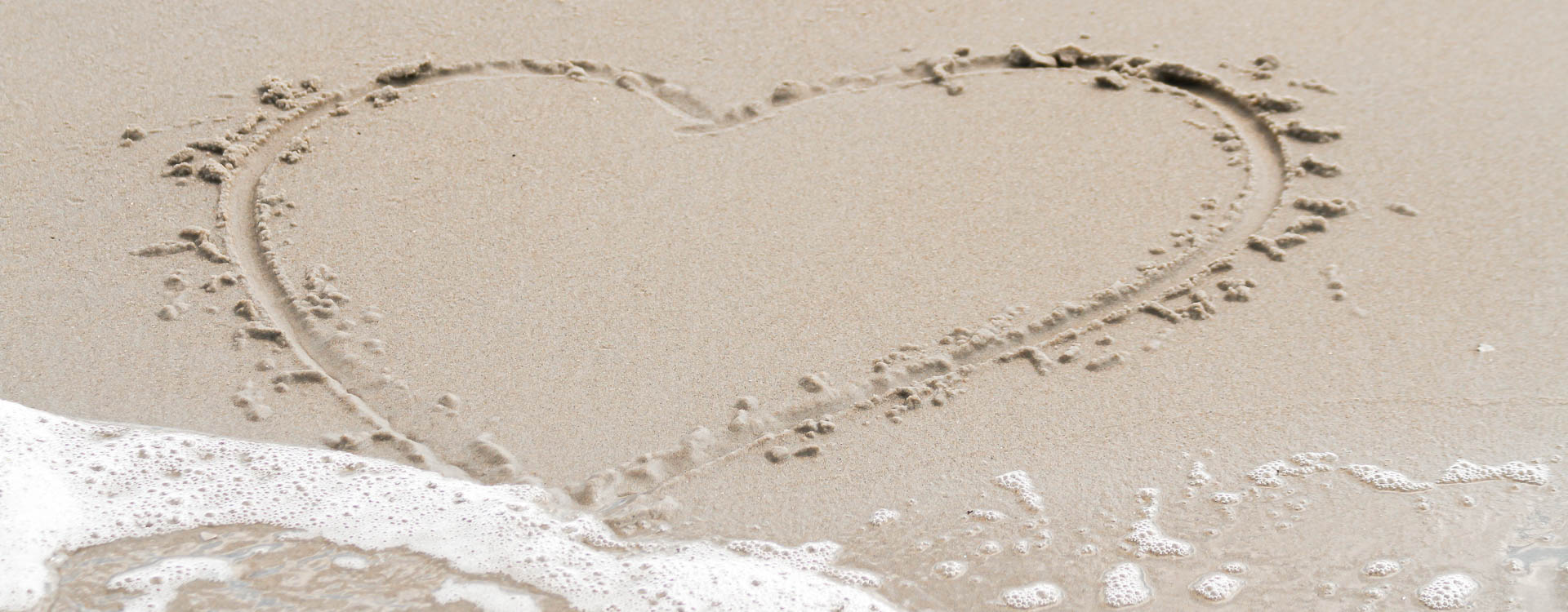 Gemaltes Herz im Sand am Strand